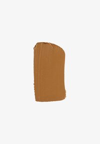 Échantillon de maquillage crémeux dans une teinte marron moyen chaude avec une texture lisse et un éclat subtil, de forme rectangulaire verticale.