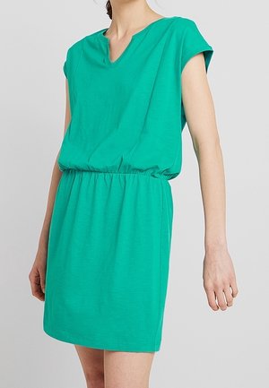 Robe à manches courtes et col en V de couleur vert vif, confectionnée dans un tissu doux, avec une ceinture élastique et une coupe ample, longueur au genou.