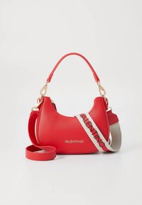 Red leather handbag with a curved shape, gold hardware, and a detachable strap featuring a logo and stripe pattern.