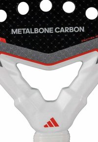 Zwarte paddle met een gestructureerd oppervlak, witte ergonomische handgreep, rode accenten en ronde perforaties. "METALBONE CARBON" bovenaan gedrukt.