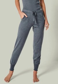 Graue Jogginghosen aus weichem, strukturiertem Stoff. Mit einem elastischen Bund mit Kordelzug und eng anliegenden Bündchen an den Knöcheln.