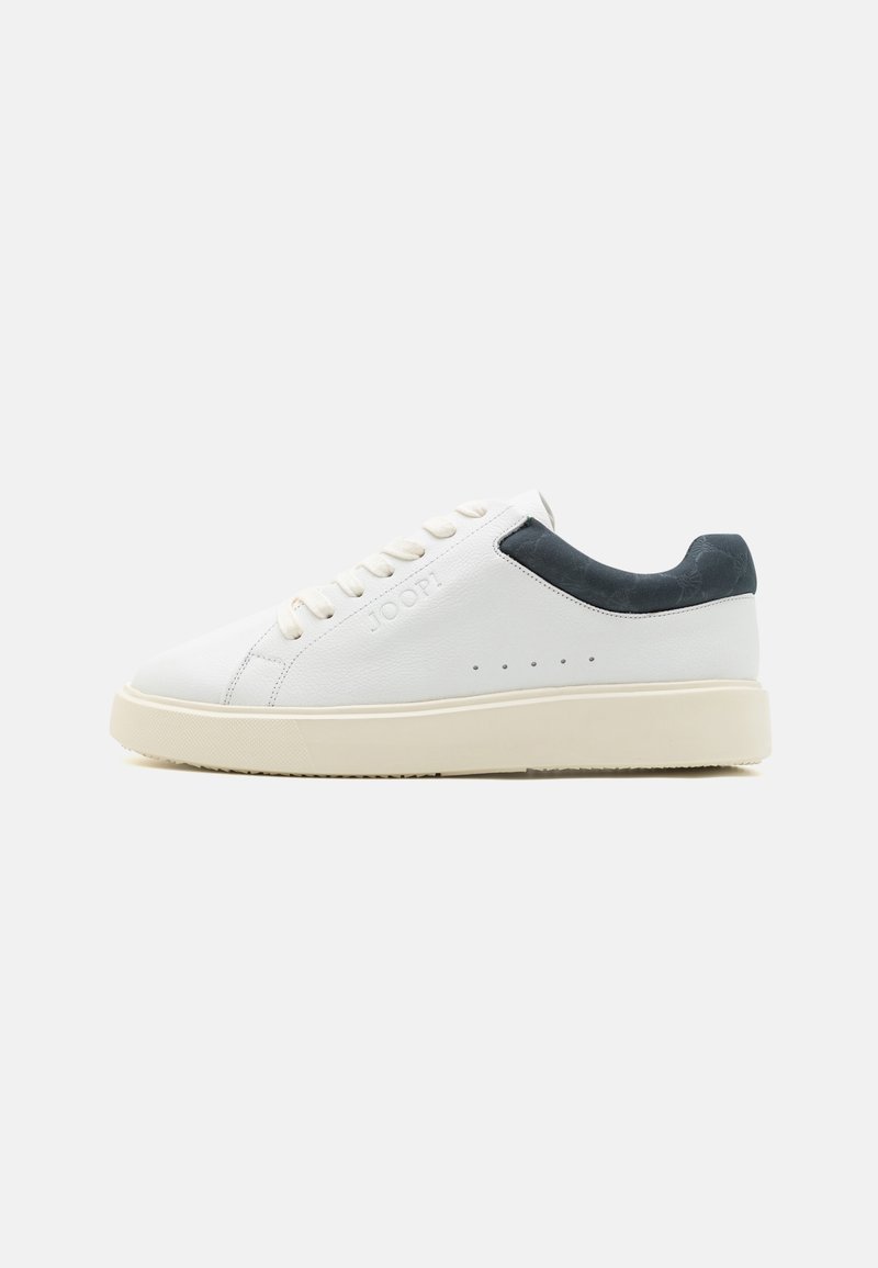 Bela usnjena športna obutev z mornarsko modrim poudarkom na peti, ravnim kremno obarvanim podplatom in vezanjem spredaj, ki vključuje šest luknjic.