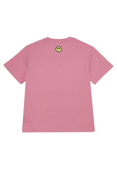 T-shirt in cotone rosa con vestibilità rilassata, maniche corte e un'etichetta a forma di faccina sorridente nera e gialla sul retro del collo. Texture liscia.