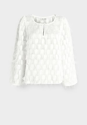 Hvid bluse med lange ærmer med teksturerede firkantede mønstre og fjerlignende frynse detaljer, med rund halsudskæring og åbning foran med nøglehul.