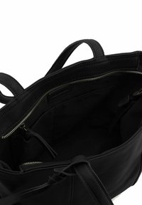 Borsa a mano in pelle nera con due manici, dotata di chiusura a zip e un interno liscio. Tasche interne e design minimalista.