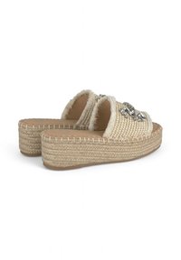 Deslizadores de estilo espadrille tejidos con un tono beige natural, que presentan una parte superior texturizada y adornos. Suela de plataforma con detalle de yute trenzado.