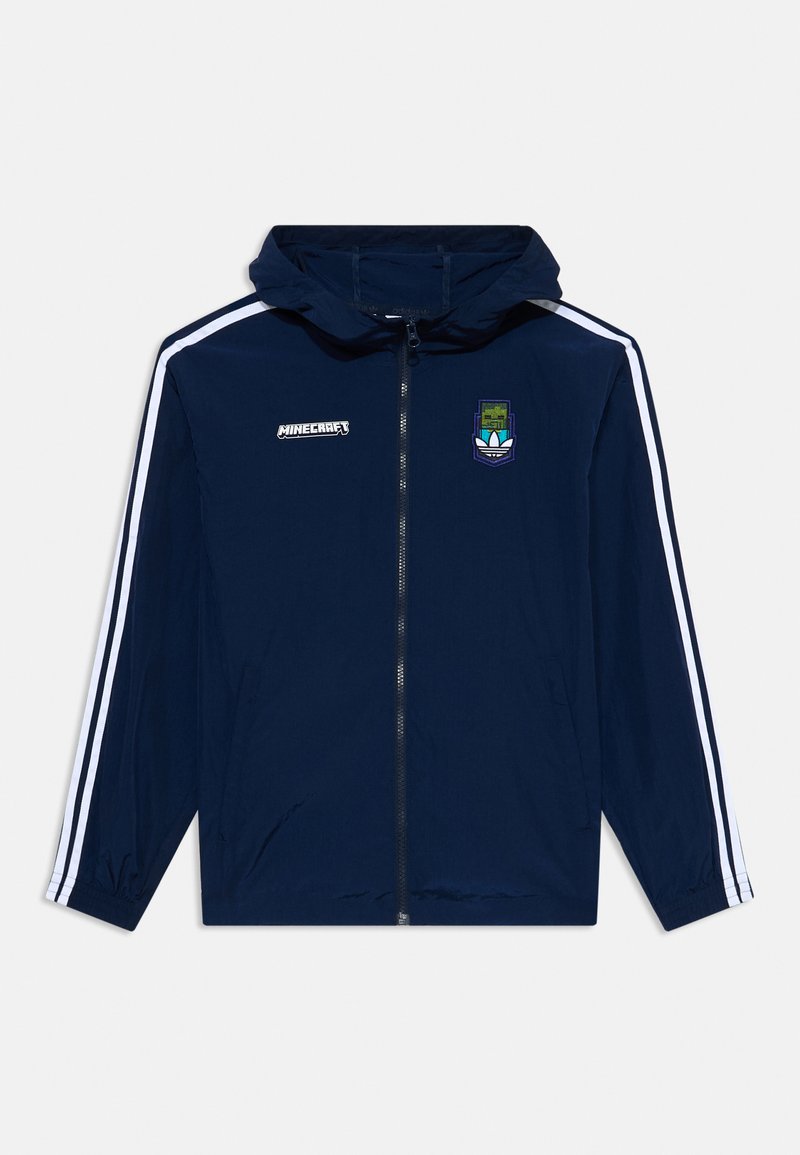 Jūras spēku vējjaka ar kapuci, baltām sānu svītrām, pilnu rāvējslēdzēju un Minecraft logotipu uz krūtīm. Vieglas, gludas tekstūras.