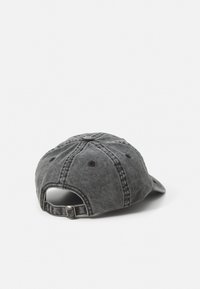 Graue Denim-Kappe mit leicht gebogenem Schirm, verstellbarem Riemen hinten und acht Belüftungsöffnungen, das ein genähtes Nahtdesign aufweist.