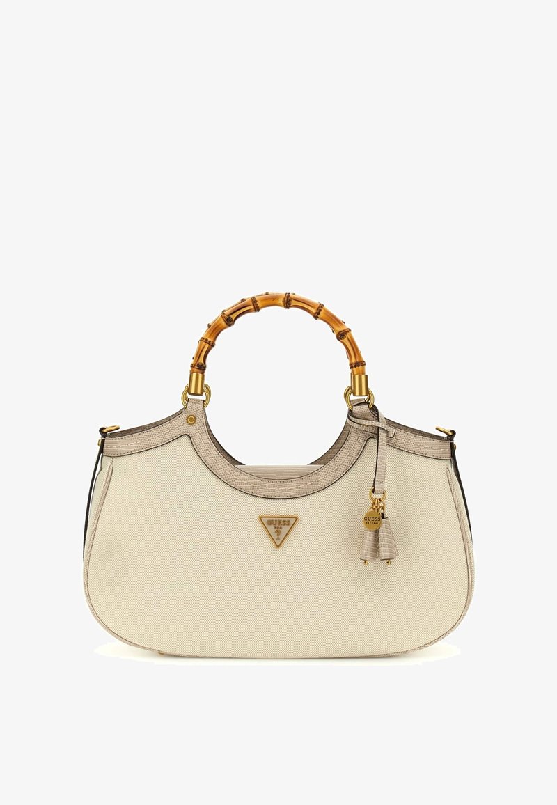 Sac à main en tissu beige avec poignées rondes style bambou, emblème du logo couleur or et breloque pompon décorative sur le côté.