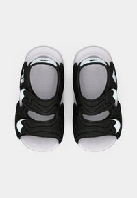 Μαύρα σανδάλια με υφασμένους πάνω ιμάντες, που διαθέτουν ανοίγματα και λευκές λεπτομέρειες, και λευκή σόλα με σχέδια για καλύτερη πρόσφυση.