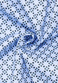 Tessuto azzurro chiaro con un motivo geometrico di diamanti blu scuro e neri, caratterizzato da una finitura morbida e texture. Adatto per vari utilizzi tessili.