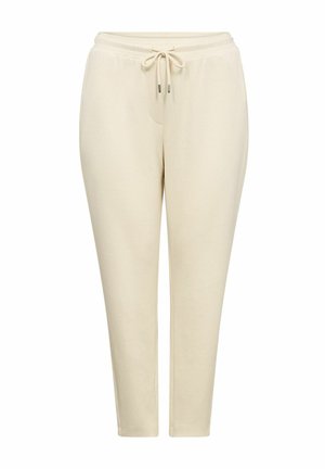 Světle béžové tapered joggingové kalhoty s elastickým pasem, nastavovací šňůrkou a bočními kapsami, vyrobené z měkké tkaniny.