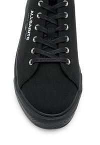 Schwarze Leinensneaker mit runder Spitze, flachen schwarzen Schnürsenkeln, silbernen Ösen und einer strukturierten schwarzen Gummisohle mit dezentem Branding.