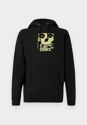 Black hooded sweatshirt in cotton blend featuring a skull graphic and "STANCE" text in yellow on the front. Front kangaroo pocket.