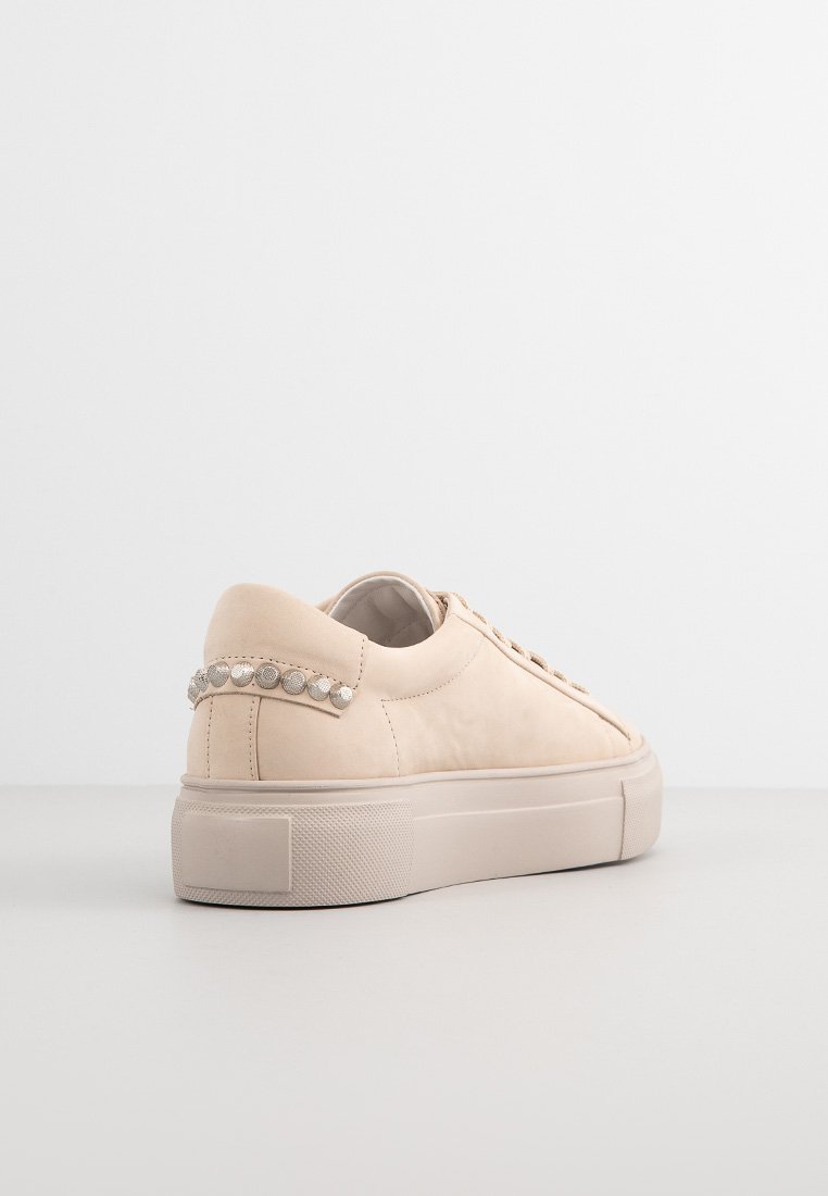 Beige Leder-Sneaker mit einem niedrigeren Schnitt, strukturierten Oberflächen und dekorativen silbernen Nieten an der Ferse. Dicke Gummisohle, minimalistischer Stil.