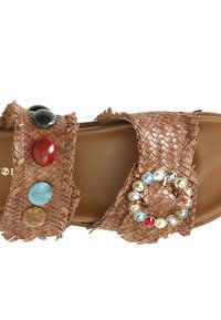 Sandali intrecciati marroni con due ampie cinghie decorate con pietre colorate e un accento circolare, con una soletta liscia color nocciola.