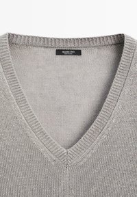 Maglione in maglia grigio chiaro con scollo a V e bordi a costine, con etichetta del marchio Massimo Dutti cucita all'interno del collo.