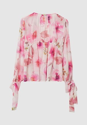 Blouse florale en tissu léger et transparent aux tons roses. Caractérisée par des manches longues avec des détails noués et un élastique froncé à la taille.