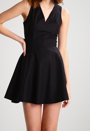 Vestito nero senza maniche con scollo a V, corpetto sagomato e gonna svasata. Realizzato con tessuto liscio e design pulito e minimalista.