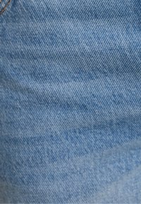 Tessuto di denim azzurro chiaro con una superficie texturizzata. Presenta un lieve motivo lavato e una trama a spina di pesce visibile, tipica dei jeans casual.