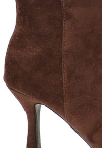 Botín de ante marrón con tacón stiletto delgado, diseño curvado, textura suave y sin herrajes ni adornos visibles.