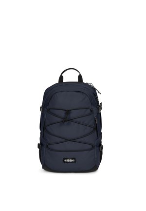 Sac à dos bleu marine avec cordon élastique noir en croisillons sur l'avant, sangles de compression latérales et une poignée de transport supérieure sur fond blanc.