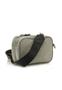 Graue Stoff-Crossbody-Tasche mit rechteckiger Form, ausgestattet mit einem schwarzen verstellbaren Tragegurt, Reißverschlussverschluss und strukturierten Details.