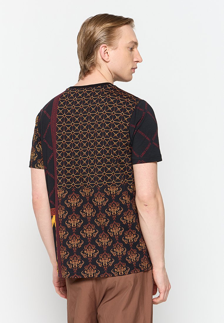 Schwarzes T-Shirt mit kurzen Ärmeln, das eine Mischung aus geometrischen und floralen Mustern in Gold und Rot zeigt. Baumwollstoff mit kontrastierenden Designs auf der Rückseite.