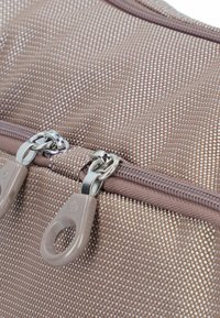 Braune, strukturiert Stofftasche mit Metallreißverschluss und Zipper-Zügen. Sie verfügt über ein gewebtes Muster und glänzende Akzente auf der Reißverschlussbeschlägen.