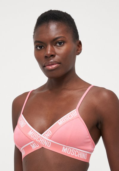 Sutien triunghiular roz din bumbac, cu detalii albe ale logo-ului Moschino, bretele subțiri și o textură netedă. Design încrucișat în față.