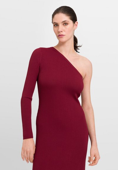 Robe côtelée à une épaule en bordeaux profond. Manches longues d'un côté, silhouette ajustée, texture douce, design à hauteur de genoux.