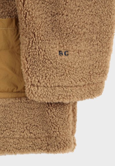 Braune Fleecejacke mit einer strukturierten, flauschigen Außenoberfläche und einem glatten Innenfutter. Verfügt über ein gesticktes "BC"-Detail.