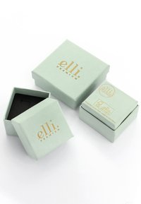 Hellgrüne Geschenkboxen mit goldener Branding, die eine glatte Textur aufweisen. Eine Box ist geöffnet und zeigt ein schwarzes Innere.