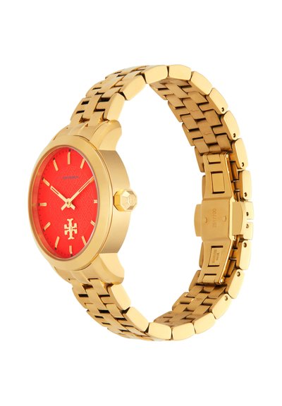 Montre-bracelet en métal doré avec cadran rouge, index et aiguilles dorés, et bracelet à maillons, présentée sous un léger angle.