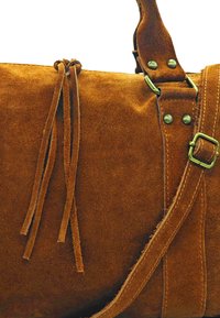 Sac en daim marron au toucher lisse, avec deux longues franges en daim, des accessoires en métal et des sangles ajustables.