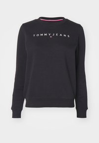 Felpa nera in cotone, con collo rotondo, maniche lunghe, polsini e orlo a coste, con il logo "TOMMY JEANS" sul petto.