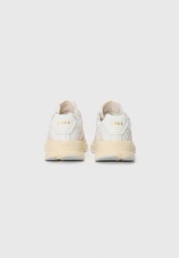 Weiße und beige Sneaker mit einem Mesh-Obermaterial, gepolstertem Kragen, goldenen Markenlogos und einer strukturierten Sohle.