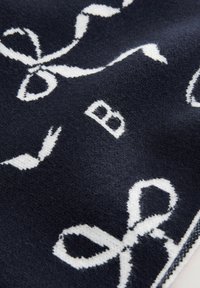 Tessuto blu navy con fiocchi decorativi bianchi e la lettera "B" in una trama morbida e testurizzata. Il design a pattern copre uniformemente la superficie.