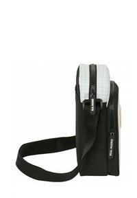 Czarna torba z białą teksturowaną górą, podwójnymi suwaczkami, regulowanym paskiem i okrągłym logo. Kompaktowy design odpowiedni do codziennego użytku.