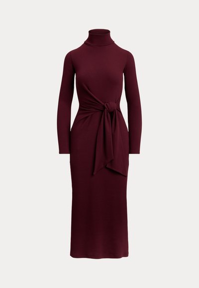 Robe à manches longues, col roulé bordeaux avec un nœud à la taille devant et un ourlet mi-long sur fond neutre.