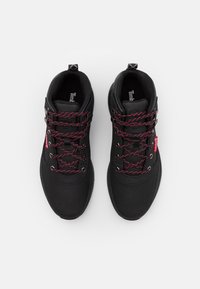 Czarne buty do wędrówek z gładką cholewką, czerwono-czarnymi sznurówkami i wyściełanym kołnierzem. Oferują metalowe oczka i metkę z logo po boku.