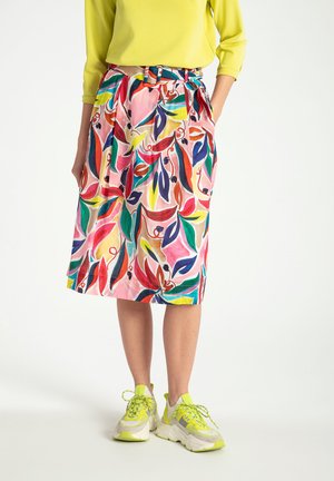 Colorful floral skirt made of lightweight fabric, featuring a belted waist and pockets, complemented by chunky white and neon sneakers.
