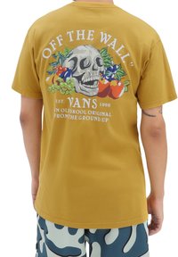 Camiseta de algodón color mostaza, vista trasera, con un gráfico de un cráneo adornado con frutas coloridas y el texto "OFF THE WALL". Mangas cortas, corte relajado.