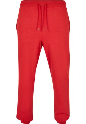 Pantalones de chándal rojos hechos de una tela suave, con cintura ajustable con cordón, puños acanalados y bolsillos laterales. Textura suave y diseño casual.