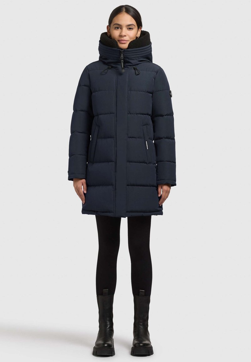 Mørkeblå dunjakke med høj krave, polstret design og to sidelommer. Jakken har en frontlynlås og er lavet af glat stof.