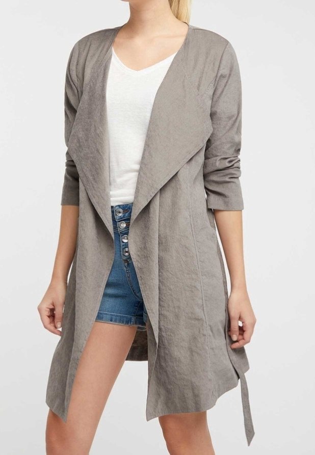 Cardigan long en tissu gris clair texturé avec un devant ouvert, des manches longues et un détail noué à la taille, porté par-dessus un haut blanc.