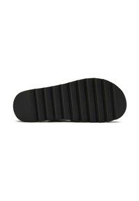 Black rubber shoe sole with horizontal ridges, rounded toe, and flat surface. Smooth texture and uniform shape without decorative elements.