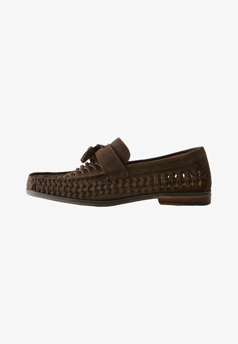 Mocassin homme en daim marron foncé avec côtés tissés, détail pompon sur le dessus et petit talon empilé.