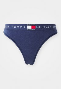 Tamsiai mėlynos spalvos medvilniniai stringai su balta juosta, ant kurios užrašyta "TOMMY HILFIGER", ir stačiakampiu logotipu, dekoruotu raudonais ir baltais akcentais.