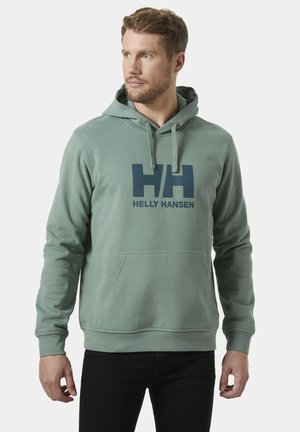Sudadera verde hecha de tela suave, con un bolsillo tipo canguro y cordones ajustables. Gran logo azul de Helly Hansen impreso en la parte frontal.